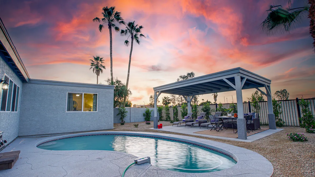 This image features the swimming pool as the central attraction, paired with an outdoor seating area and a stunning sunset sky. The scene radiates a serene mood, perfect for evening relaxation after a day in the sun.