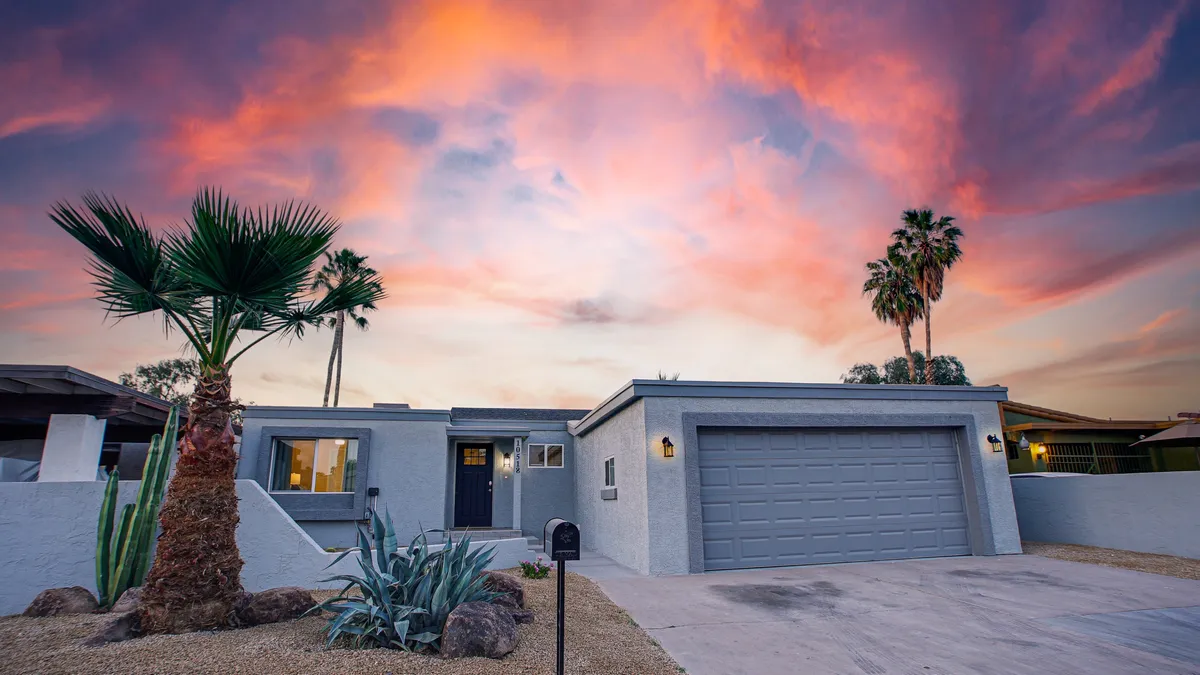 The property’s exterior is showcased at dusk, with multiple palm trees framing the modern architecture. The sky glows with rich sunset colors, highlighting the tranquil yet lively setting. This view hints at the relaxing evenings guests can enjoy after nearby events.